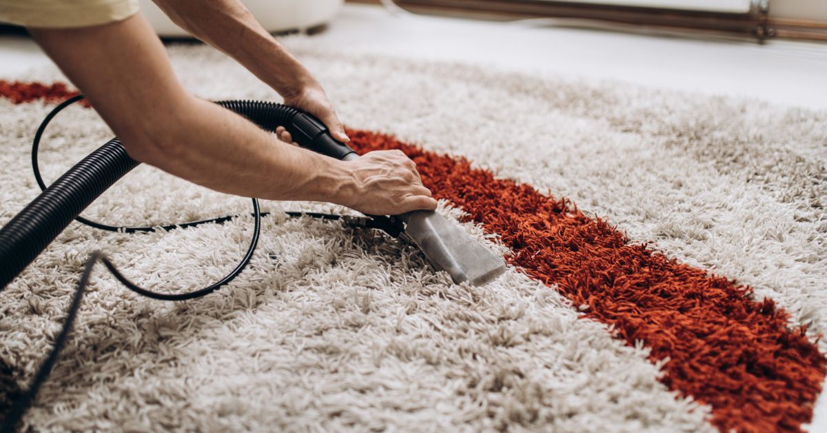 What is the best way to remove deep-set soot and dust from an antique rug without damaging the natural lanolin in the wool?